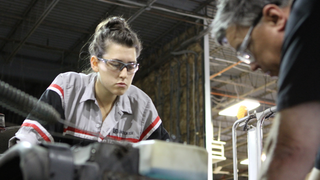 A Lincoln Tech Student works with her instructor on a diesel truck engine.