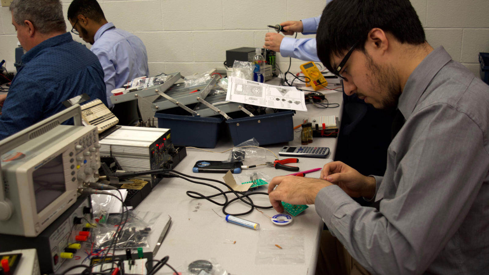 An Allentown electronics tech student prepares a circuit board for soldering.