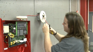 An Electrical student learns how to wire an alarm system.