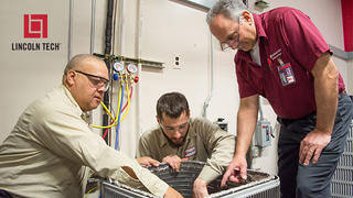 A master HVACR instructor oversees students working on an HVAC system.