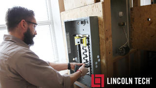 A Student in the Lincoln Tech Electrical Program Wires a Circuit Breaker Box