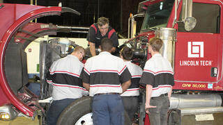 A diesel instructor teaches a group of student technicians proper diesel engine diagnosis