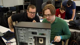 Two Allentown students discuss construction of a desktop computer tower.